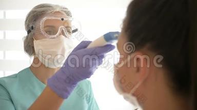 护士戴着医用口罩和眼镜，用非接触式红外温度计测量病人`体温。
